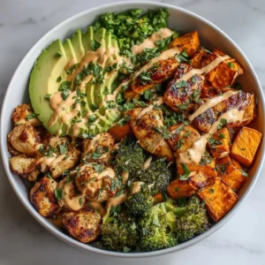 Healthy chicken and sweet potato rice bowl topped with fresh vegetables